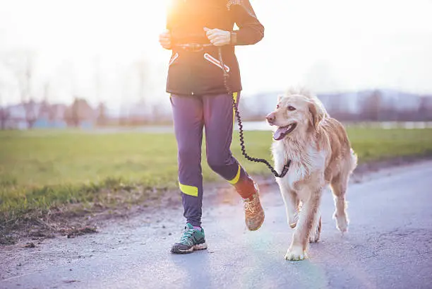 A senior woman running outdoors with her dog