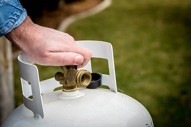 Man closes a knob on a propane tank Propane tank valve being closed propane photos stock pictures, royalty-free photos & images