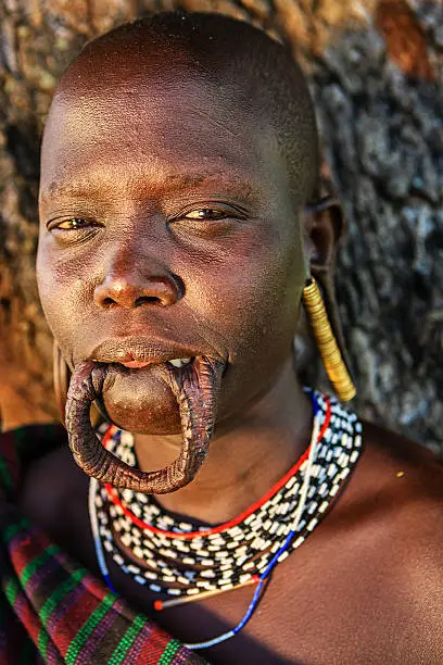 Portrait of woman from Mursi tribe. Mursi tribe are probably the last groups in Africa amongst whom it is still the norm for women to wear large pottery or wooden discs or ‘plates’ in their lower lips.http://bem.2be.pl/IS/ethiopia_380.jpg