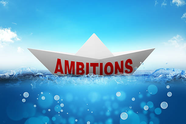 istock Origami paper boat with word ambitions 516608174