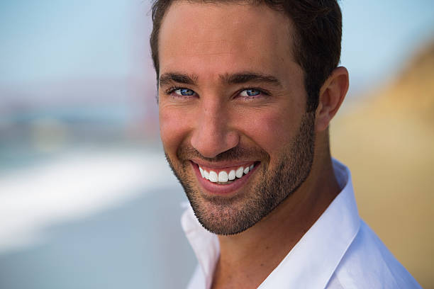 istock Portrait of handsome young man at beach 516614521