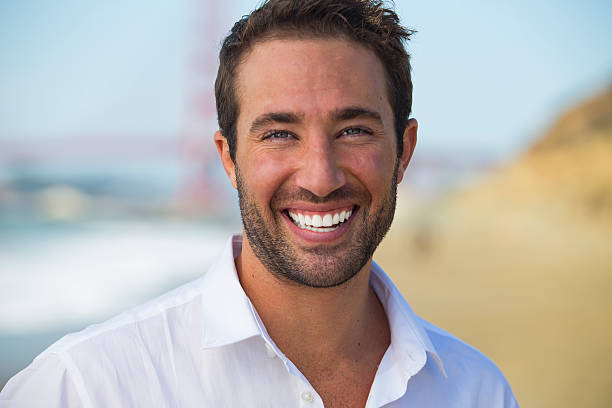 istock Portrait of handsome young man at beach 516614561