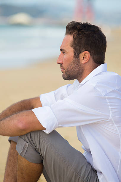 istock Side profile of young man at beach with serious look 516615399