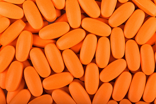 bulk orange pills closeup background