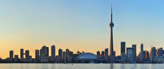 Toronto sunset over lake panorama with urban skyline.
