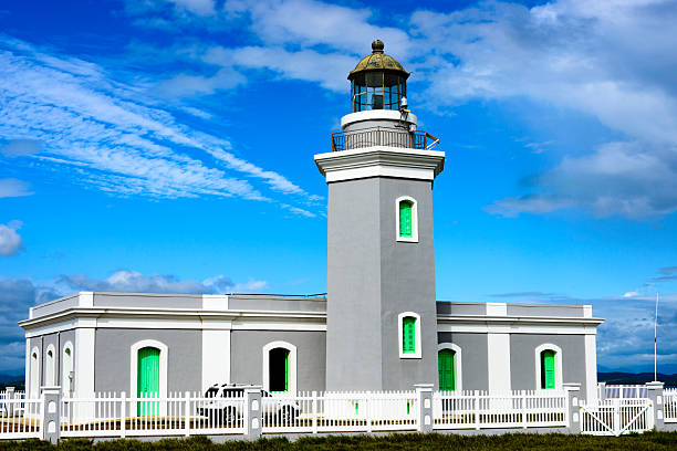 Los Morrillos lighthouse in Cabo Rojo, Puerto Rico.  The lighthouse is surrounded by a white picket fence.