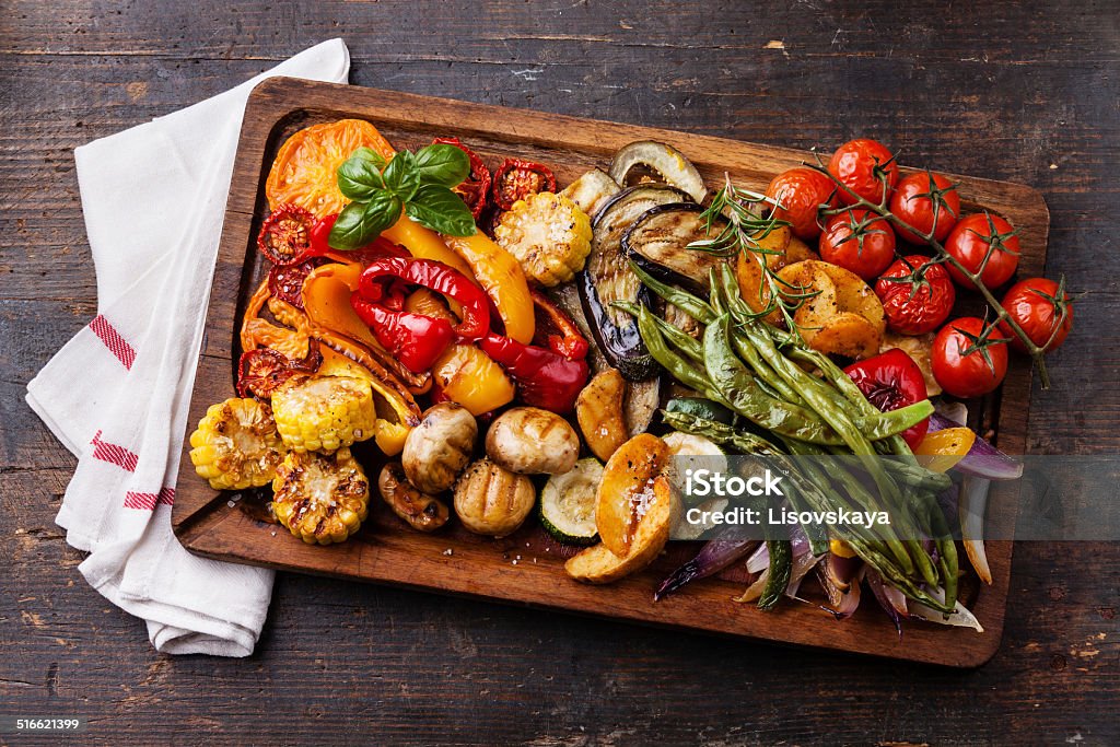 Grilled vegetables on cutting board Grilled vegetables on cutting board on dark wooden background Vegetable Stock Photo