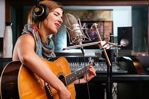 Young singer Young woman with guitar recording a song in the studio recording studio stock pictures, royalty-free photos & images