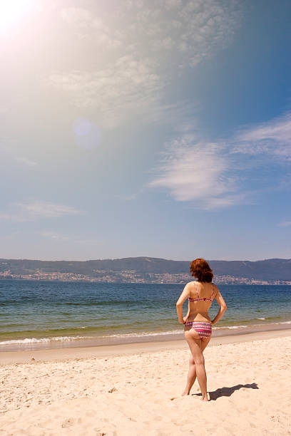 istock Young woman standing on the beach 516622124
