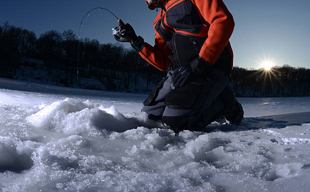 Ice fishing on a lake in winter Man ice fishing on a lake in winter ice fishing stock pictures, royalty-free photos & images