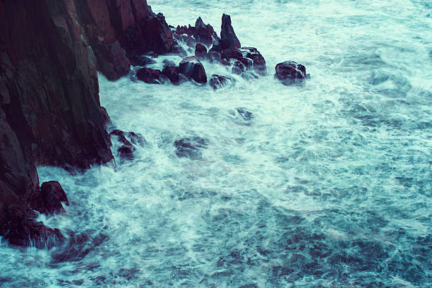 Crashing tide against the rocks stock photo