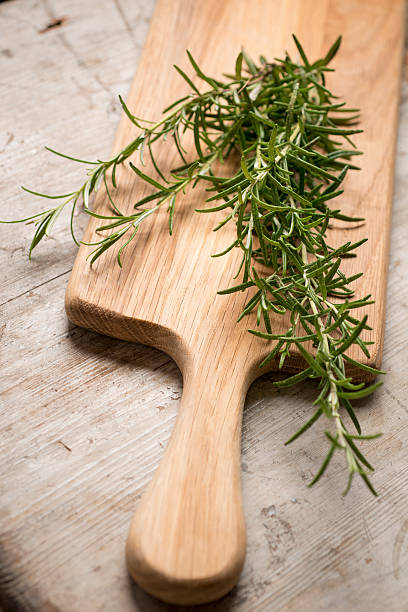 istock Chopping board with rosemary lying on top 516632320