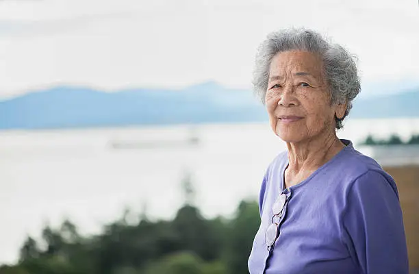 Photo of Independent Senior Asian Woman Enjoying View from Apartment, Vancouver, Canada