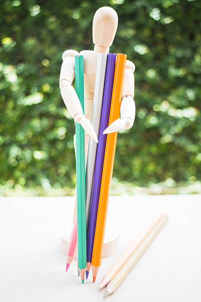 木製 manikin とカラー鉛筆のアーティストのワークテーブル - mannequin book education doll ストックフォトと画像