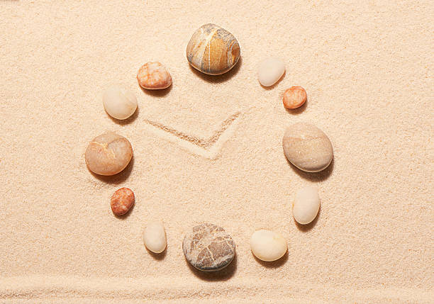istock Watch from sea stones on sand. Summer beach background 516634030