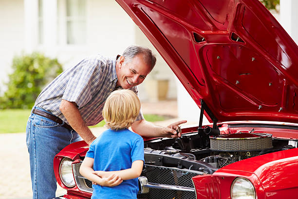 istock Grandfather And Grandson Working On Restored Classic Car 516634663