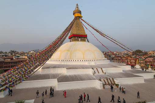The massive mandala of Bouddha stupa, the UNESCO World Heritage Site at Boudhanath spotlit at sunset in the heart of Kathmandu, Nepal’s vibrant capital city.