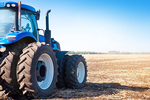 istock Blue tractor on the background of an empty field 516635492