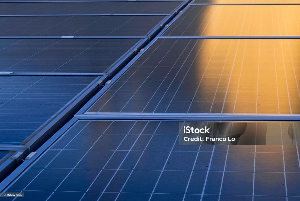 Solar mirrors . Solar energy system in foreground for private homes,lit by the sunset sun. Solar Panel Stock Photo