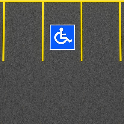 Handicap parking space  in a parking lot.  Universal symbols painted on the asphalt.