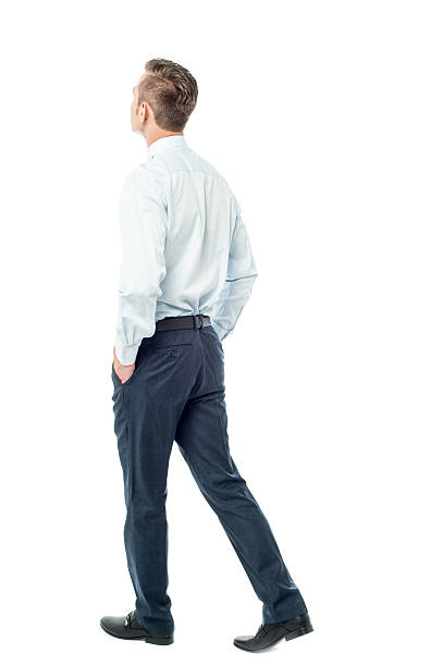 Businessman walking forward, hands in pocket stock photo