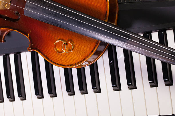 istock Piano keyboard, old violin and wedding rings 516645178