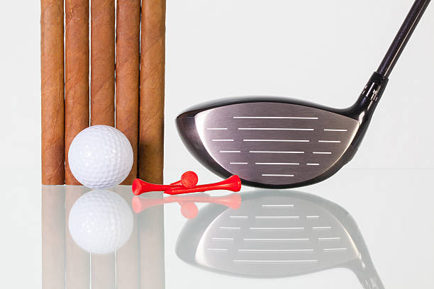 istock Golf driver and different cigars on a glass desk 516645434