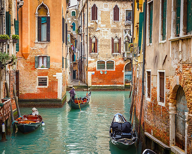 gondolas on canal in venice - gondol yolcu teknesi stok fotoğraflar ve resimler