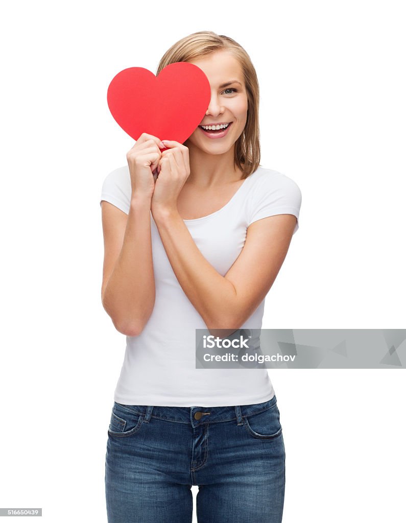 smiling woman in blank white t-shirt with heart happiness, t-shirt design, health and love concept - smiling woman in blank white t-shirt with covering half face with heart Adult Stock Photo