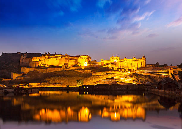 Amer Fort at night in twilight. Jaipur, Rajastan, Amer Fort Amber Fort illuminated at night - one of principal attractions in Jaipur, Rajastan, India refelcting in Maota lake in twilight amber fort stock pictures, royalty-free photos & images