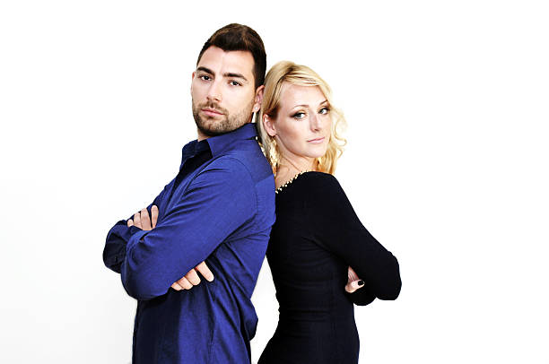 istock Young couple standing with their backs together isolated on white. 516651231