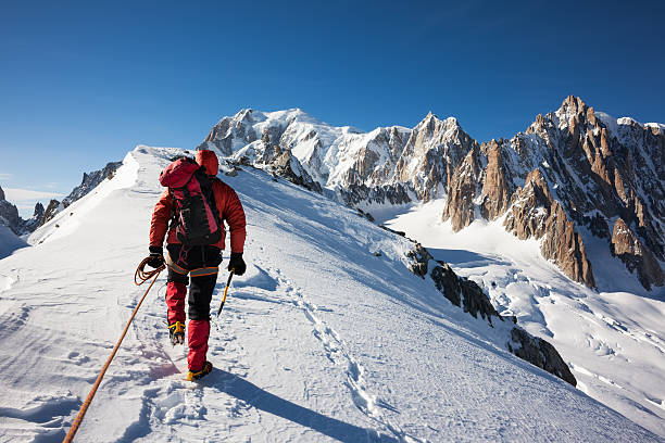 Mountaneer climbs a snowy ridge in Mont Blanc Mountaneer climbs a snowy ridge in Mont Blanc, France. Enterprise, diligence, team work: mountaneering concepts. mountain climbing photos stock pictures, royalty-free photos & images
