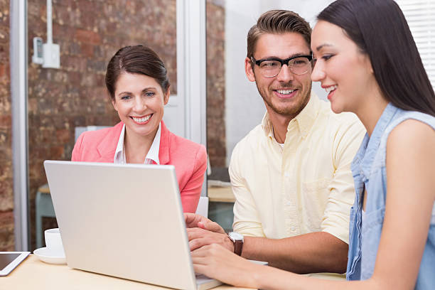 istock Smiling business team using laptop and having coffee 516651679