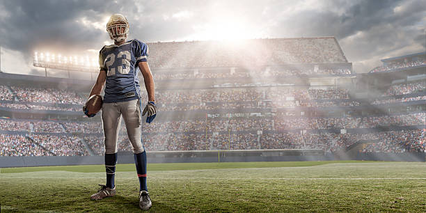 jogador de futebol no estádio iluminado pela luz - football player american football sport determination imagens e fotografias de stock