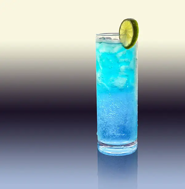 a blue longdrink with slice of lemon in gradient artificial back
