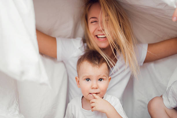 istock Young mother and son playing and smiling under a blanket 516652760
