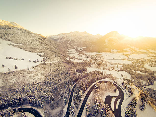 a mountain road is winding through a snowy landscape in the german alps