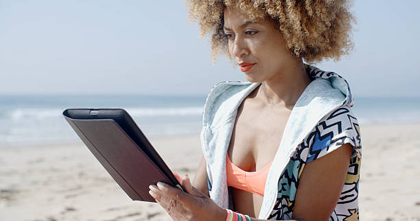 istock African American Girl Using Tablet Pc At Beach 516654516