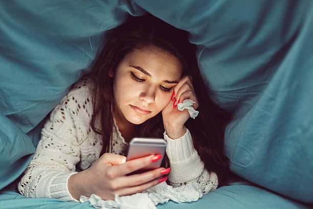 istock Crying girl in bed texting on smartphone 516654620