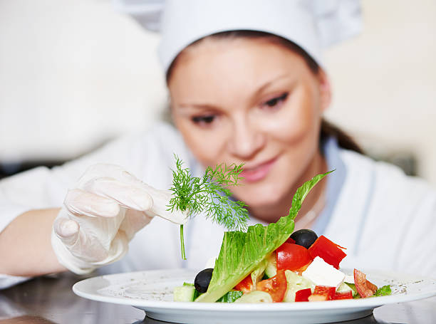 istock female cook chef decorating prepared salad food 516655140