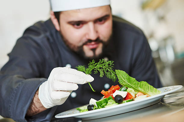 istock male chef decorating salad food 516655192