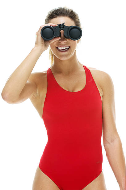 istock Smiling female lifeguard searching with binocular 516656335