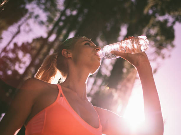 istock Runner drinking water from a bottle with early sunflare 516656434