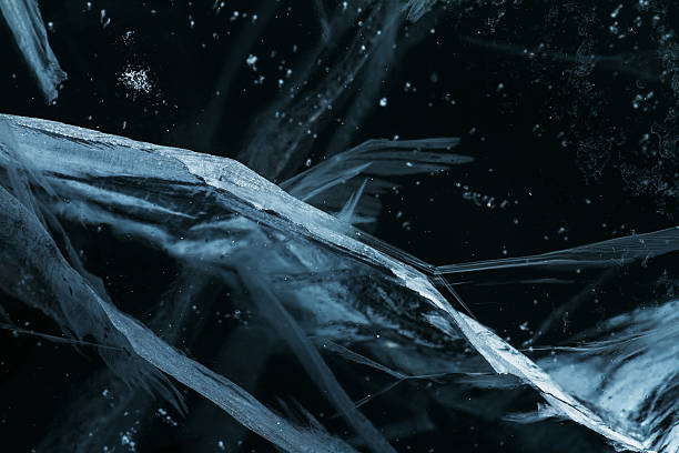 frozen pond, black and white cracked ice closeup
