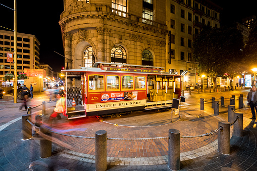 San Francisco, USA - February 20, 2015: Cable car at the end of the line being turned by the conductor in San Francisco, California. People can be seen walking by the street.
