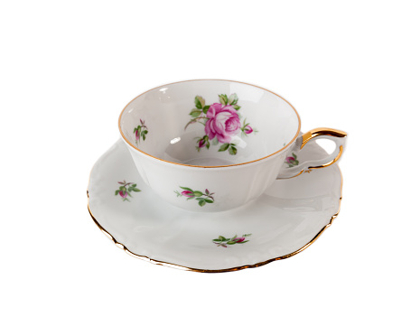 Porcelain teacup and saucer with floral rose ornament in classic isolated over white