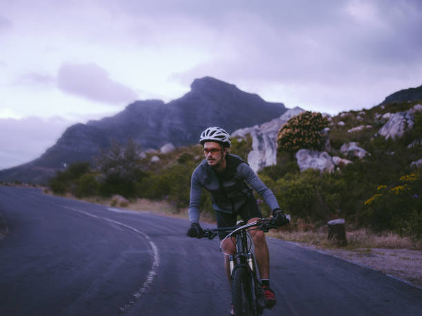 istock Determined cyclist in recreational pursuit with bicycle on mountain road 516660118