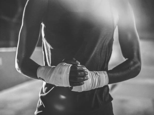 Unrecognizable close up shot of african-american boxer hands ready for the fight in an urban city setting late at night