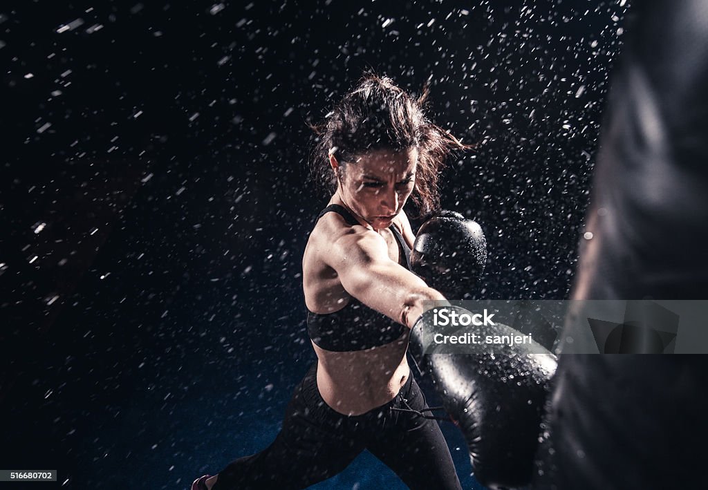 Boxing power Young woman boxing at the punching bag Boxing - Sport Stock Photo