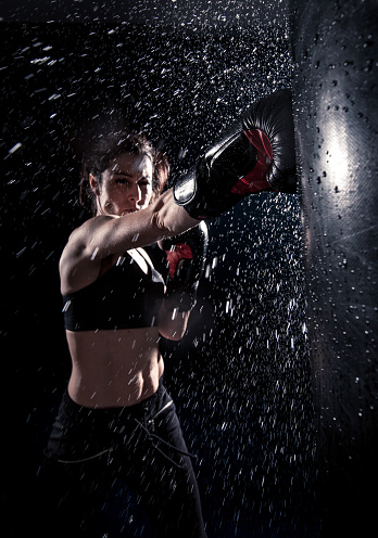 Young woman boxing at the punching bag